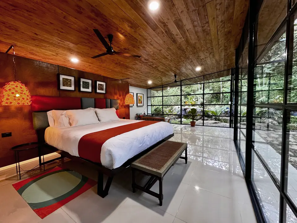 Habitación de Cascada Suite con ventanales hacia el jardín