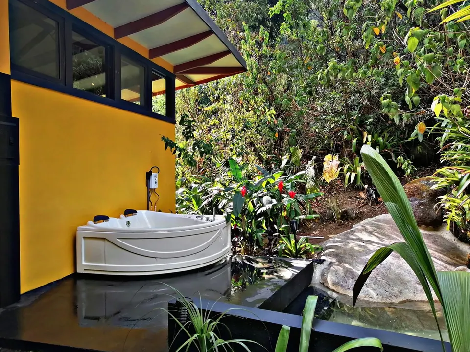 Jacuzzi doble al aire libre junto a las paredes amarillas de Casita Amarilla