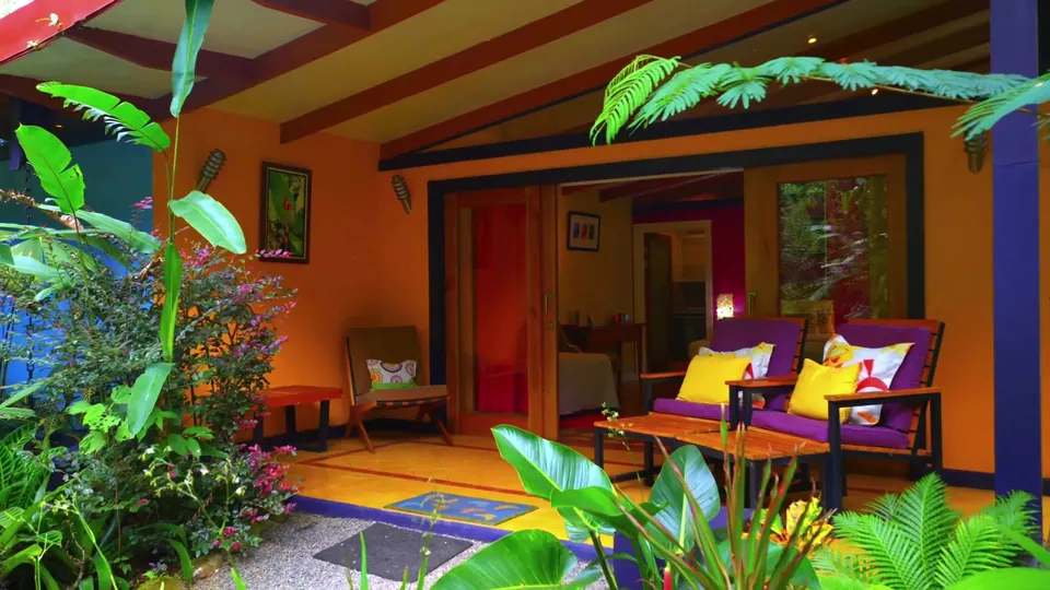 Terraza de Casita Naranja con paredes naranja y sillones morados