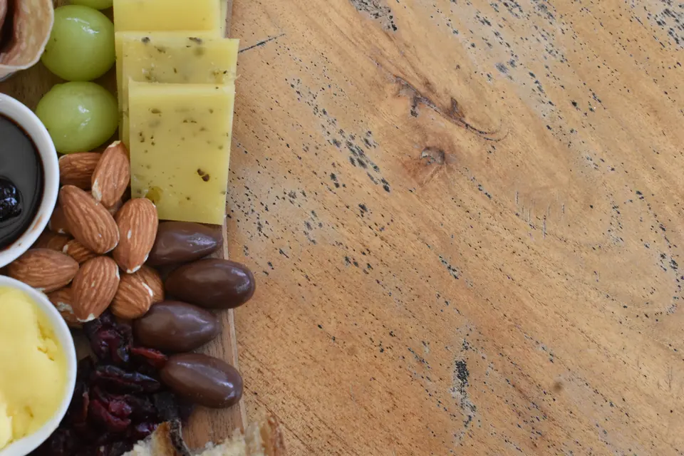 Local cheeses, almonds and chocolates on a wooden board