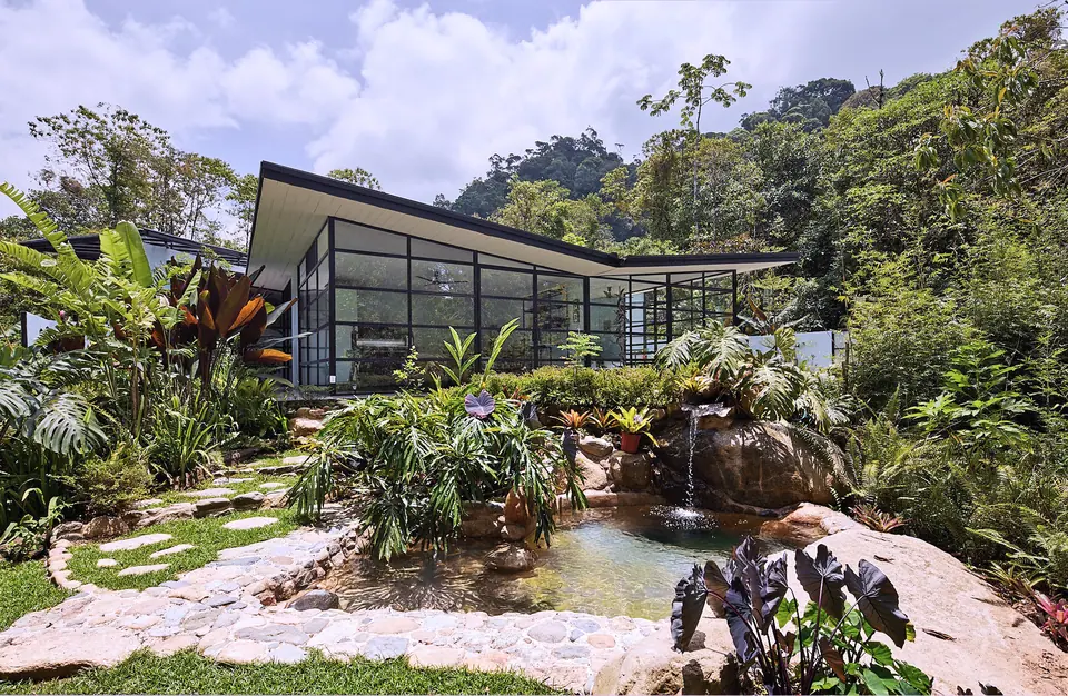 Garden pond and waterfall beside a glass-walled suite