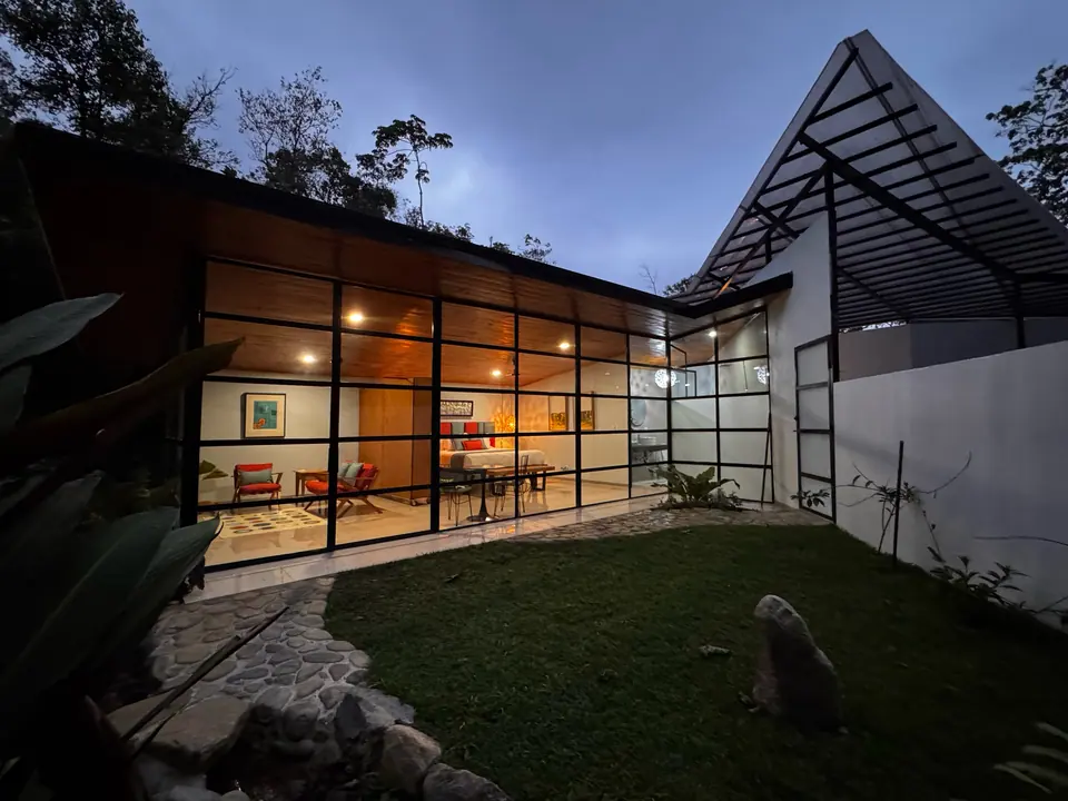 Glass-walled suite glowing at dusk